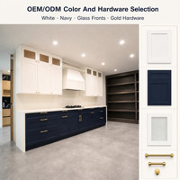 Set Kabinet Dapur Modern Ramah Lingkungan Warna Putih dan Biru Dongker dengan Pintu Kaca, Meja Marmer, Perlengkapan Emas, dan Penyimpanan Terbuka di Dinding