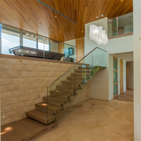 Escalier flottant résidentiel en acier et bois, construction durable avec poutres métalliques, garde-corps en verre transparent, écologique, sûr pour une utilisation en intérieur