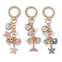Nouveau porte-clés élégant en forme de coquillage, de queue de poisson et d'étoile de mer avec des perles et un charme en forme de cœur