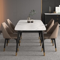 Table à manger moderne et simple, style 2021, avec plateau en pierre frittée et pieds en métal noir.