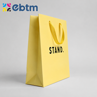 Sacs cadeaux en papier jaune mat personnalisés en gros avec poignées en ruban noir pour sacs cadeaux cosmétiques