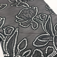 Tissu en cuir PU perforé brodé à découpe laser noire à motif floral abstrait pour manteau et textile de maison