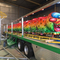 Manège pliable géant Caterpillar vert sur remorque, équipement d'amusement portable, idéal pour les fêtes foraines nomades.