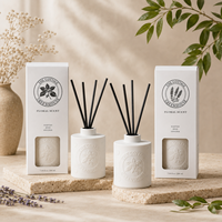 Diffuseur de parfum en céramique blanche de 200 ml personnalisé par Arovi-Factory, avec bâtonnets noirs et boîte cadeau avec fenêtre.