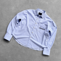 Chemise boutonnée pour homme, coupe ample, style preppy streetwear, à manches longues, avec logo personnalisé, rayures fines bleues et blanches, ourlet court et broderie.