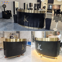 Comptoir d'information pour hôtel et spa, comptoir personnalisé pour salon, comptoir de réception de bureau moderne de luxe en Corian noir incurvé avec éclairage LED