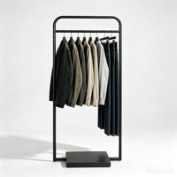 Porte-vêtements moderne minimaliste en métal noir avec cadre à coins arrondis et base lourde centralisée pour boutique de créateurs