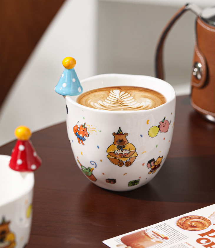 Un petit ours dans un chapeau bleu tient une tasse