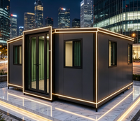 Maison conteneur modulaire noire à éclairage LED, pour showroom urbain, magasin éphémère, cabane de glamping de luxe urbaine, installation rapide