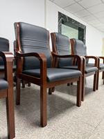 Chaise de bureau moderne à prix abordable avec pieds fixes, en cuir, accoudoirs en bois massif, chaise de visiteur exécutive pivotante pour projets commerciaux et achats groupés