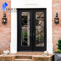 Porte d'entrée double noire moderne avec inserts en verre en fer forgé à motif losanges pour maison en briques
