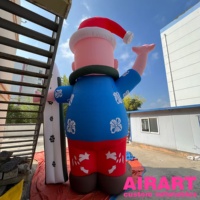 Le Père Noël gonflable portant une chemise pour l'activité de surf carré Décoration de Noël