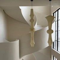 Escalier de villa courbé de style crème, artistique et durable, avec des contours doux et tourbillonnants, construction métallique moderne pour intérieur, garde-corps en fer forgé