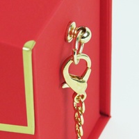 Rote Goldfolie Kosmetik- und Schmuckverpackung mit Kettengriff, Karton-Geschenkbox in Handtaschenform mit Schlitzen für Uhren, recycelbar