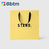 Sacs cadeaux en papier jaune mat personnalisés en gros avec poignées en ruban noir pour sacs cadeaux cosmétiques