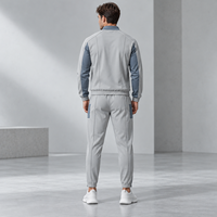 Ensemble de survêtement personnalisé pour homme en polyester interlock avec veste bomber à empiècements contrastants et pantalon à fermeture éclair aux chevilles pour le sport et le quotidien