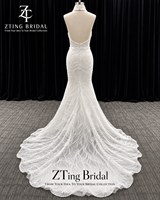 Robe de mariée sirène à col montant perlé et dos nu, broderie de perles sur toute la surface, coupe ajustée et évasée avec ourlet festonné