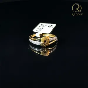 Elegante anillo de oro con diseño de doble banda, con piedras brillantes y un detalle de encanto único, perfecto para uso diario y ocasiones especiales. - Product Image 1