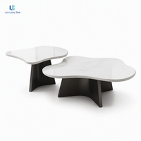 Table basse gigogne en marbre Luca Volakas |   Ensemble de tables d'appoint organiques, plateau blanc poli, base noire thermolaquée, fabrication sur mesure de luxe