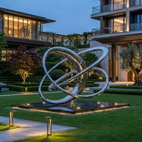Sculpture circulaire abstraite en acier inoxydable plaqué argent poli miroir, design tendance pour jardin extérieur et piscine