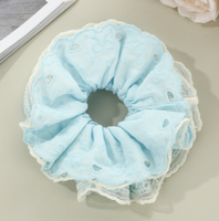 Bandeau pour cheveux avec dentelle ajourée en forme de cœur et cordon à franges pour une coiffure chignon douce et charmante.