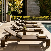 Ensemble de mobilier de jardin : canapé rembourré, table d'appoint ronde, table basse gigogne en pierre, chaise longue réglable
