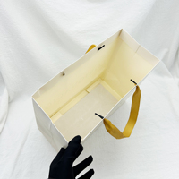 Bolsa de papel de compras reutilizable con impresión de logotipo personalizado de marca de lujo reciclable con asa de cinta