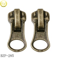 Sacs personnalisés fabriqués en usine OEM, étiquettes à fermeture éclair, tirettes de fermeture éclair à logo creux pour vêtements de créateur et valises