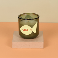 Bougie parfumée AIKUN en verre à double mèche, ouverture large, couleur brun chaud, avec arôme d'Oud et accent décoratif logo doré, idéale pour les salles de spa