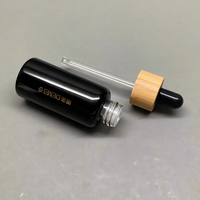 Vente en gros de flacons compte-gouttes en verre noir brillant de 30 ml avec compte-gouttes en bambou et impression sérigraphique pour les gouttes pour les yeux et les sérums pour le soin de la peau