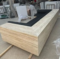 Canapé d'angle en travertin sur mesure, moderne, écologique, avec structure en pierre beige et coussins en cuir noir, idéal pour appartement de luxe