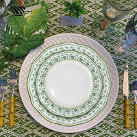 Ensemble d'assiettes en porcelaine élégantes avec motifs floraux verts complexes et accents dorés pour une décoration de table de mariage intemporelle