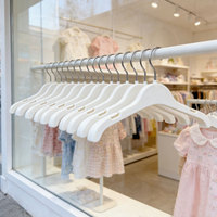 Cintres en plastique blanc pour enfants, vente en gros directe usine, avec crochet pivotant en métal et mini fentes pour sangles, personnalisables