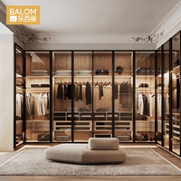 Système de dressing intégré moderne et luxueux avec portes vitrées, finition bois chaud et éclairage LED, sur mesure pour chambre à coucher