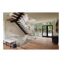 Escalier moderne à poutre monobloc en acier, marches flottantes en chêne, balustrade en verre