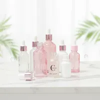 Flacons cosmétiques vides en verre cylindrique rose doré de 30 ml et rose translucide de 50 ml avec impression sérigraphique