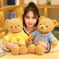 Ours en peluche mignon aux cheveux bouclés brun clair avec t-shirt rouge, personnalisable avec logo du fabricant