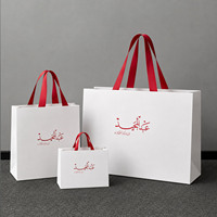 Sac de shopping en papier blanc de luxe avec logo arabe personnalisé et ruban en satin rouge pour boutique du Moyen-Orient