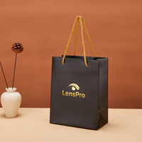 Sac cadeau en papier noir personnalisé avec poignées en ruban pour l'emballage de vêtements, de produits de beauté et de bijoux, vente en gros, haute qualité