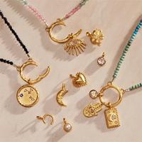 Collier Pendentif à Breloques Design Manna, Œil Protecteur, Soleil, Lune, Initiale et Pierre de Naissance en Or 18 Carats Personnalisé pour Femme
