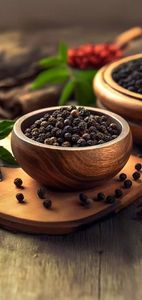 Granos de pimienta negra en cuchara de madera sobre fondo negro para condimentar en la cocina - Product Image 2