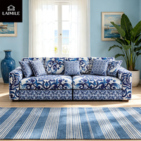 Canapé 3 places en tissu floral bleu et blanc de luxe, style vintage, avec coussins assortis, pour salon de villa.