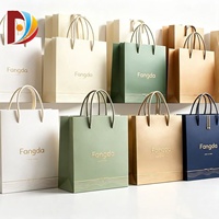 Emballage cadeau écologique en carton ivoire avec poignées en corde de coton et impression dorée en relief, personnalisable pour les marques d'entreprise