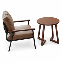 Fauteuil lounge moderne rembourré avec structure métallique et table d'appoint ronde, idéal pour les salons, hôtels, cafés et bureaux.