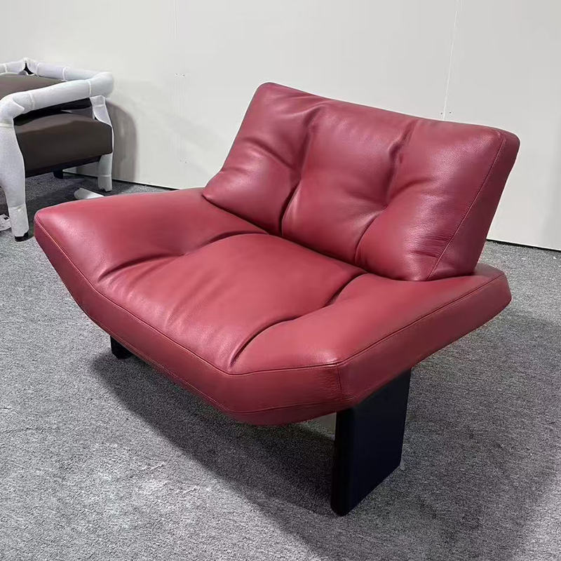 Fauteuil individuel avec pieds en bois massif et revêtement en cuir microfibre rouge.