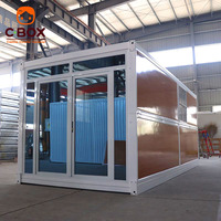 Maison pliable en bois grainé Cbox avec porte coulissante en verre, maison préfabriquée modulaire en conteneur pliable