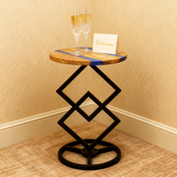 Table d'appoint ronde en bois d'olivier naturel et résine époxy avec base géométrique en métal pour le salon et la chambre à coucher.