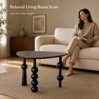 Table basse moderne de forme organique avec trois pieds sphériques noirs pour canapé et salon