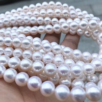 Perles de culture d'eau douce blanches naturelles en gros près de perles d'eau douce naturelles en vrac rondes