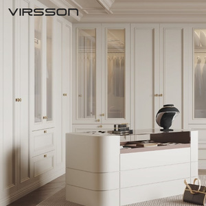 Système de <span class=keywords><strong>dressing</strong></span> de <span class=keywords><strong>luxe</strong></span> avec armoires courbes couleur crème, supports d'angle dorés, îlot de présentation et piliers cannelés, conception personnalisée - Product Image 1